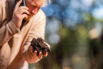 university student conducting research on forest health. farmer collecting soil samples in a test...