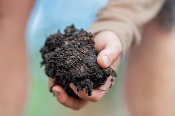 farmer holding soil in hand and pouring soil on ground. connected to the land and environment. soil agronomy in australia. soil heath study