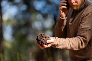 farmer hold soil in hands monitoring soil health on a farm.