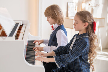 Two children are playing the piano.