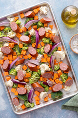 Sheet pan dinner with sausage and vegetables ready to be roasted