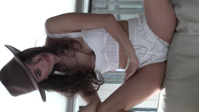 CFC2022VV  Ukrainian female model in casual setting dressed in knit white lingerie with cowboy hat 4K in vertical format