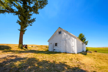 A small white home and shop in Rockford, Washington, part of the rural Palouse area of Eastern Washington near Spokane Washington, USA.