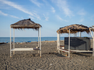 Abandoned decorative houses with thatched roofs on the seashore. Off-season. Lack of tourists.