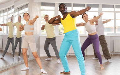 Fototapeta premium Energy African man teacher and founder of martial arts school conducts self-defense lesson for course multinational visitors. Active lifestyle, hobbies, skill building