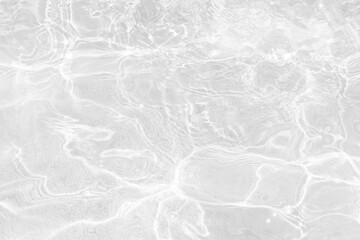 White water with ripples on the surface. Defocus blurred transparent white colored clear calm water surface texture with splashes and bubbles. Water waves with shining pattern texture background.