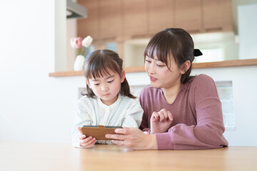 スマートフォンを使う親子　女の子とお母さん