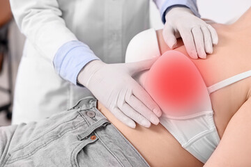 Mammologist checking woman's breast in hospital, closeup