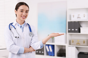 Medical consultant with stethoscope in clinic, space for text