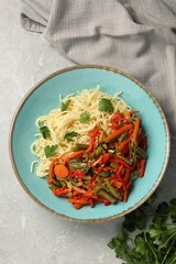 Vegetarian meal. Tasty pasta with vegetables on light grey marble table, top view