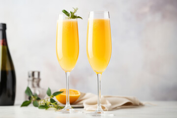 Naklejka premium Classic mimosa or bellini cocktail in flute glasses, brunch cocktails with champagne wine with copy space