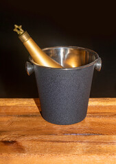 Glass champagne bottle inside wine chiller bucket on a table - 785799115