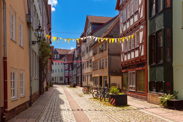 Traditional timber-framed houses line the cobblestone street leading to Marburg Castle, Germany - obrazy, fototapety, plakaty