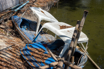 An old abandoned pedal boats on a shore