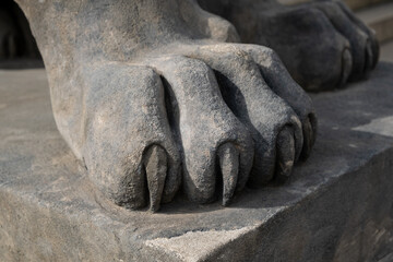 Fototapeta na wymiar Majestic lion statue'powerful rock stonr paws, symbolizing the historical significance and architectural beauty. close-up