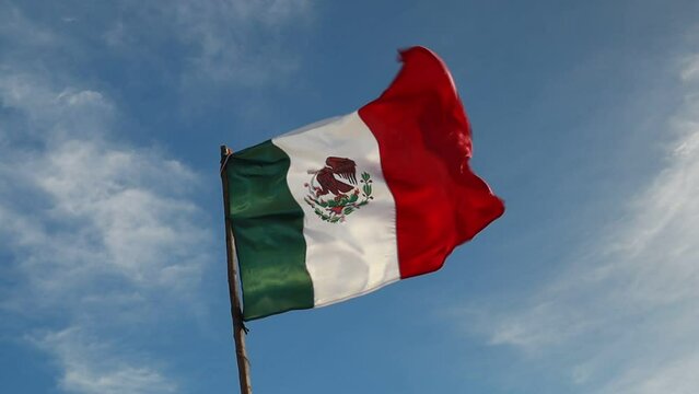 bandera de M&eacute;xico con cielo azul de fondo 