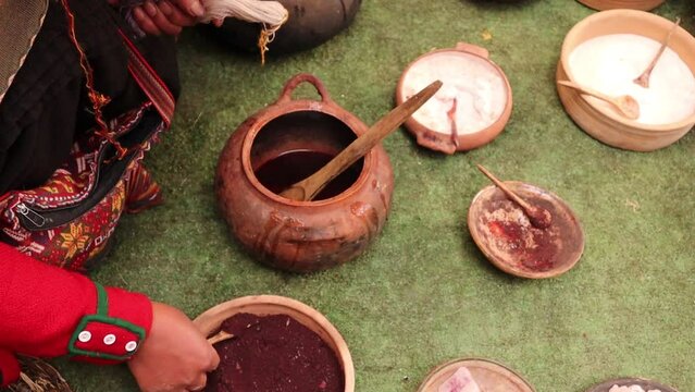mujer peruana haciendo te&ntilde;ido tradicional de hilos de alpaca en chinchero cusco peru