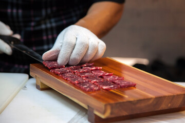 preparing the beef sashimi on the wooden board
