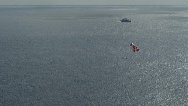 Majestic drone shot around parasail soaring through the air