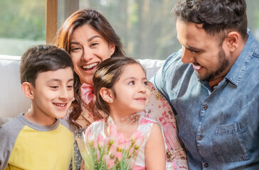 Family shares in the living room of their home and enjoys the day.