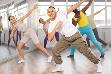 Active young Asian man practicing hip-hop dance in training hall during dancing classes