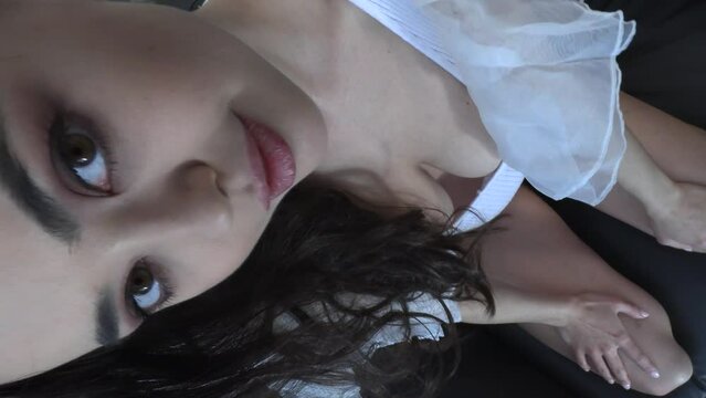CFC2022VV  Ukrainian female model in casual setting dressed in white lingerie with feathery wings 4K in vertical format