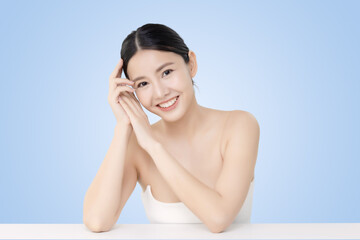 Close-up portrait of young Asian beautiful woman with healthy skin isolated on light blue background for skincare commercial product advertising.