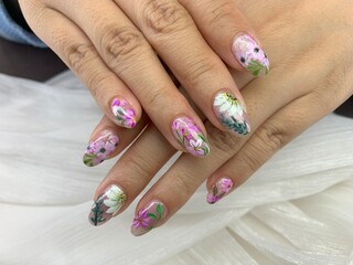 An Easter-inspired acrylic nails set featuring intricate designs of flowers and bunnies adorning a girl's hand, evoking the essence of springtime joy