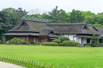茅葺屋根の古い日本家屋がある日本庭園の春の情景