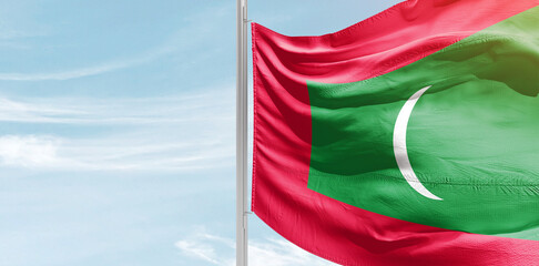 Maldives national flag with mast at light blue sky.