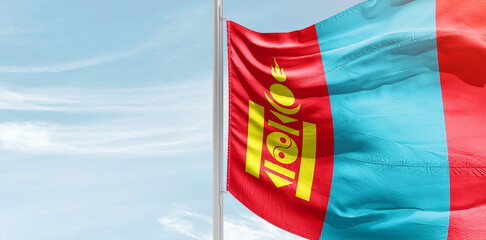 Mongolia national flag with mast at light blue sky.