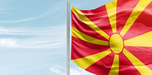 North Macedonia national flag with mast at light blue sky.