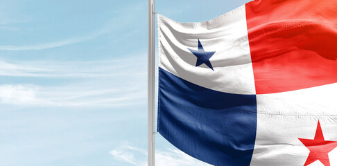 Panama national flag with mast at light blue sky.