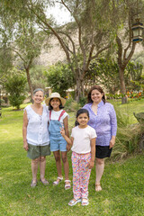 Fototapeta premium A family of four posing for a picture in a park