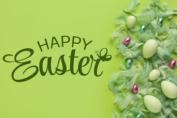 Easter eggs, candies and feathers on green background. Top view