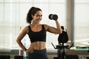 Healthy strong latina female holding dumbbells lifts weights exercise in gym. sport training weights fitness, Exercise to lose weight, take care of health. - obrazy, fototapety, plakaty