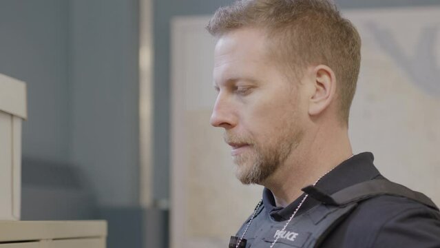 Police officer putting on his badge zoom in
