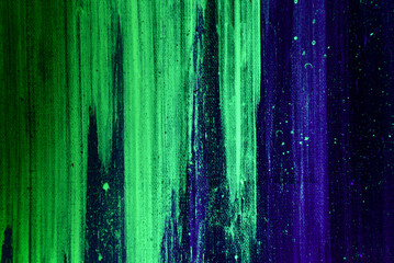 flecks and strokes of fluorescent paint on canvas lit by blacklight