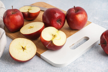 Board with fresh red apples on white background