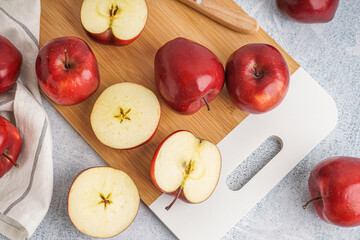 Board with fresh red apples on white background