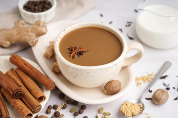 Cup of tasty masala tea with different spices on light background, closeup