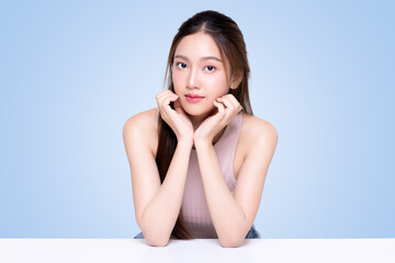 Beautiful young Asian woman with healthy and perfect skin on isolated blue background. Facial and skin care concept for commercial advertising.