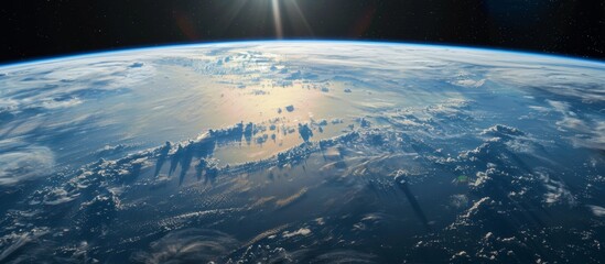 The stunning vista of the earth as seen from outer space, bathed in sunlight with the shining sun in the background