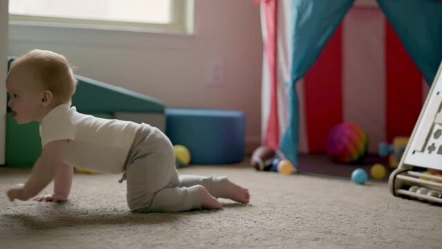 one year old  boy crawls across the room, crowling stage