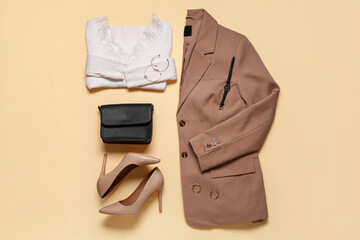 Stylish beige jacket with longsleeve,  high heels, bag and accessories on beige background