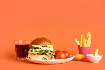 Tasty burger with french fries, glass of cola and sauces on orange background