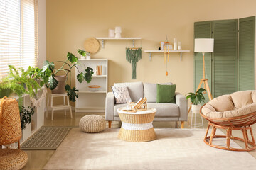Interior of light living room with wind chime, sofa and plants - obrazy, fototapety, plakaty