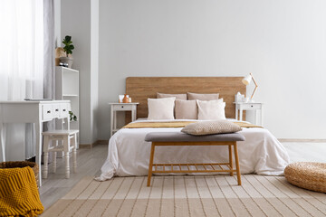 Interior of light modern bedroom with big bed, shelving units and bedside table