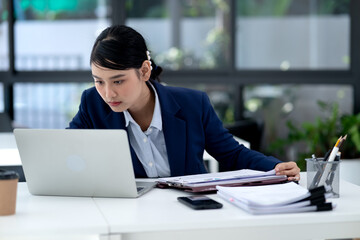 businesswoman Concentrating on work  looking at documents and laptop