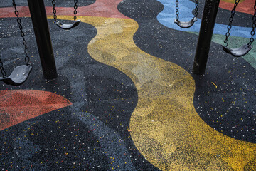 A school playground with an abstract design, swings and slides creating a pattern that symbolizes play and physical activity
